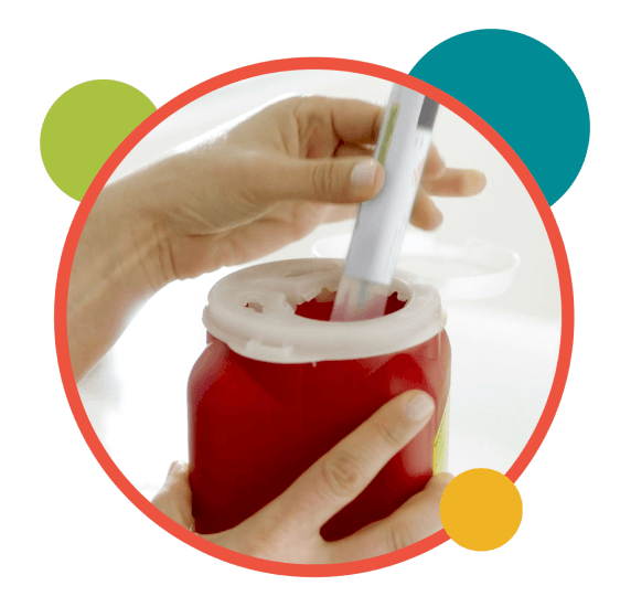 hands disposing a syringe in a sharps container